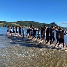 Young people lined up in the water