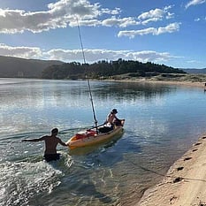 Kids playing - one in the water and one in a kayak