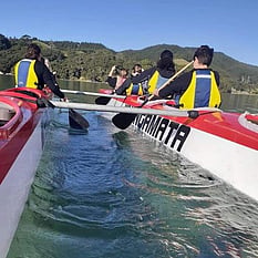 Kids in a double hulled kayak
