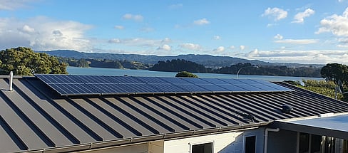 Solar panels installed on roof in the Bay of Plenty, water and hills in the background