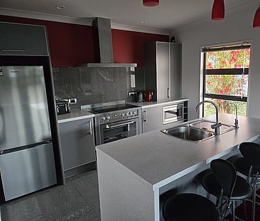 The grey and white kitchen and island bench at 14 Cologne Street