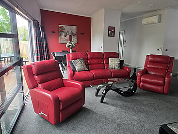 Living room of 14A Cologne Street with red leather sofa and lazy boy chairs