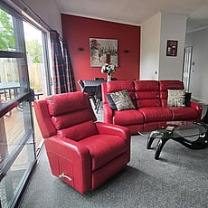 Living room of 14A Cologne Street with red leather sofa and lazy boy chairs