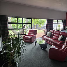 Living room of 14A Cologne Street with red leather sofa and lazy boy chairs