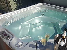 Luxurious spa pool with a champagne bottle in a cooler at Villa Rosa