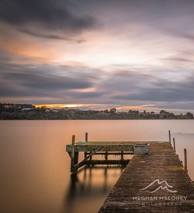 Wooden dock stretching into a still lake under overcast skies, Cambridge NZ