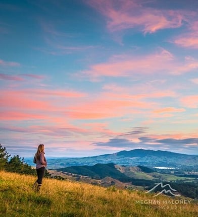 Person watching the sunset from a hilltop near Cambridge NZ