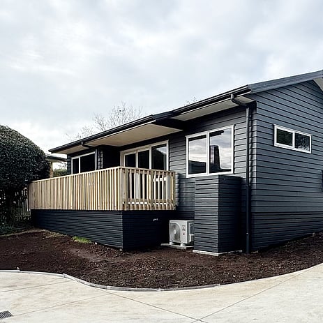 Image of a moody dark blue cladded small building with decking on Vercoe Road. Built by Ardent Building Developments, Hamilton. Waikato, New Zealand.