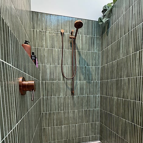 Image of a beautiful vertical finger tiled shower with copper fittings in this Bedford Road bathroom extension. Built by Ardent Building Developments, Hamilton. Waikato, New Zealand.