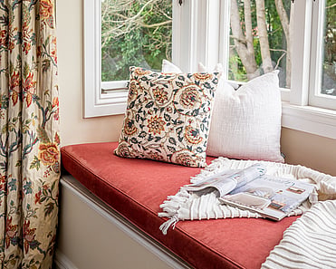 Close up image of window seat and floral print cushion and curtains in newly renovated master bedroom. Renovated by local Te Awamutu residential builders, Whitechurch Construction.