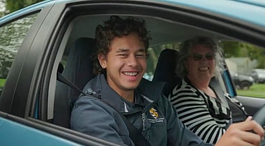 Two people smiling in a car