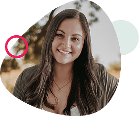 Smiling woman with long dark hair, wearing a white top and olive cardigan, framed by abstract beige and pink shapes