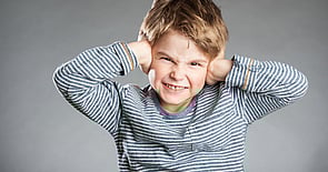 Young boy blocking his ears