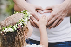 Small child feeling pregnant belly. 