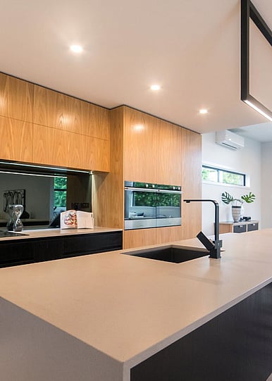 Modern Kitchen with wooden panels and white stone island