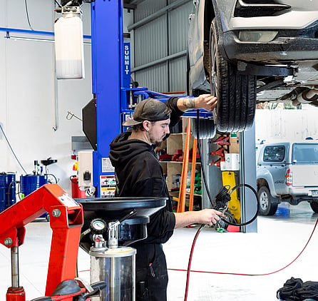 Man servicing a car checking tire pressure