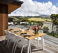 Master bedroom ensuite opening to private balcony — coastal home, Raglan estuary view