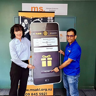 A giant cheque being presented to Multiple Sclerosis Auckland