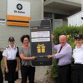 A giant cheque being presented to St Johns