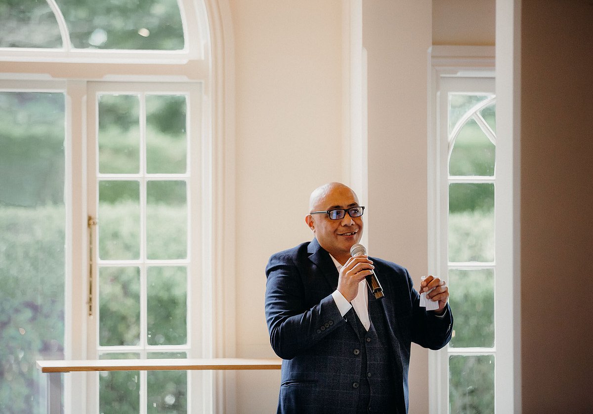 Vito MCing a wedding reception in Canterbury, microphone in hand