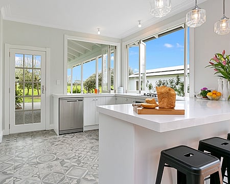 Image of fresh white kitchen with vintage tiled flooring on Oakshott Road, renovated by Whitechurch Construction, Waikato residential builders.