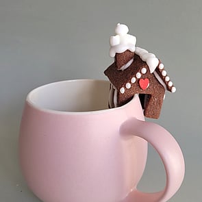 Three gluten-free eclairs in a dish with white squiggly icing on top and pansy flower decoration