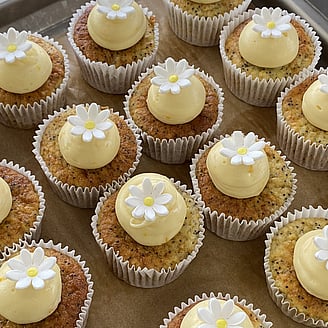 Photo of beautiful gluten free cupcakes with pale pink icing and white sprinkles