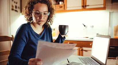 Young women sitting by herself looking at computer screen