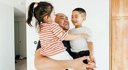 Father having fun teaching his son to ride a bike