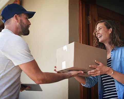 Man handing woman a box of printing