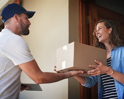 Man handing woman a box of printing