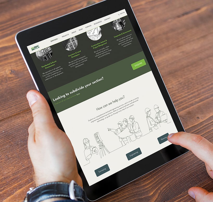 A person holds a tablet displaying the RPC website, showing services like surveying and planning, with a clean design and green accents