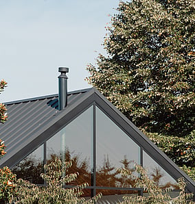 Barn-style architectural rural home near Matamata with cedar cladding and large glazed gable end facing the rural outlook, built by MB Construction, residential builders for Matamata and the Bay of Plenty