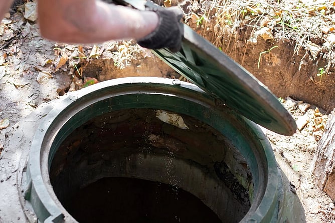 Man opening a man hole to check drainage