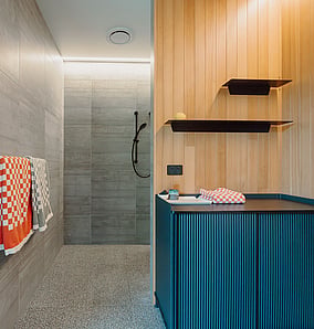 Main ensuite walk-in shower in an architectural rural home in Matamata with terrazzo floor, tiled walls and frameless glass screen, built by MB Construction.