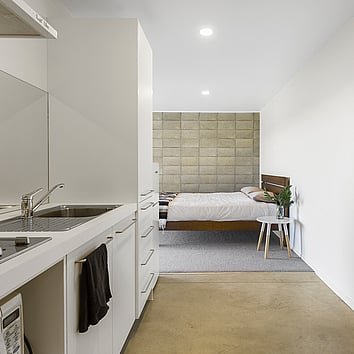 Modern home with concrete floor and concrete feature wall in the bedroom 