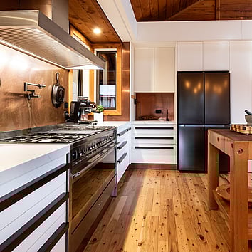 large gas oven in a modern kitchen with natural timber flooring and ceiling. 