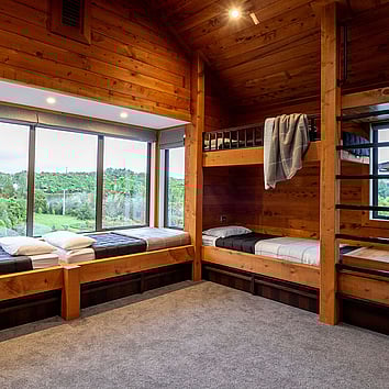 rustic timber bedroom with build in bunk beds and large window seat