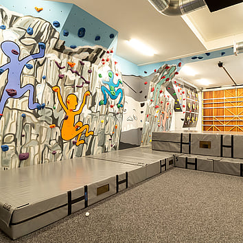 indoor climbing wall with art murals painted on the walls