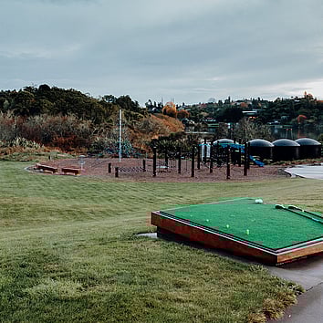 outdoor driving range with kids play park in the distance. 
