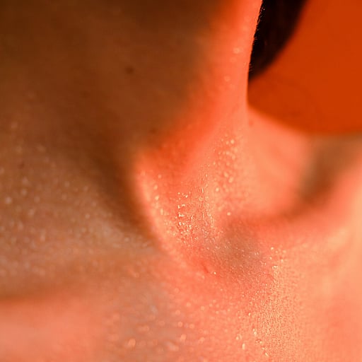 A therapists hands applying a body scrub to a clients skin.