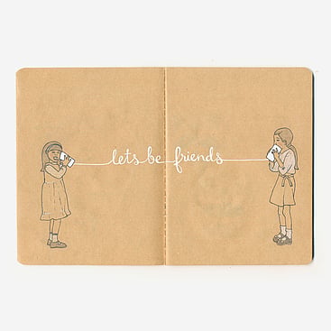 Kraft paper notebook sketch of two girls and tin can phone saying "lets be friends"