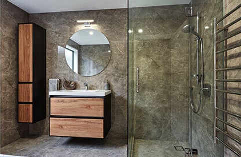 This bathroom renovation in Auckland includes large floor to ceiling tiles, beautifully crafted wooden cabinets and a large, tiled shower.