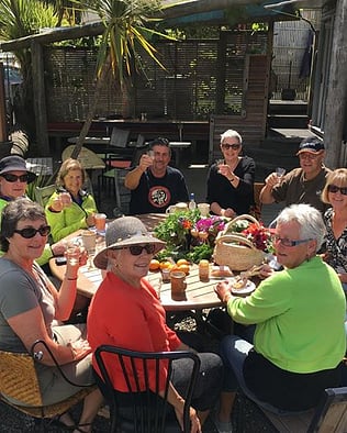 Locals sitting around a table swapping produce etc in Kuaotunu on the Coromandel Peninsula