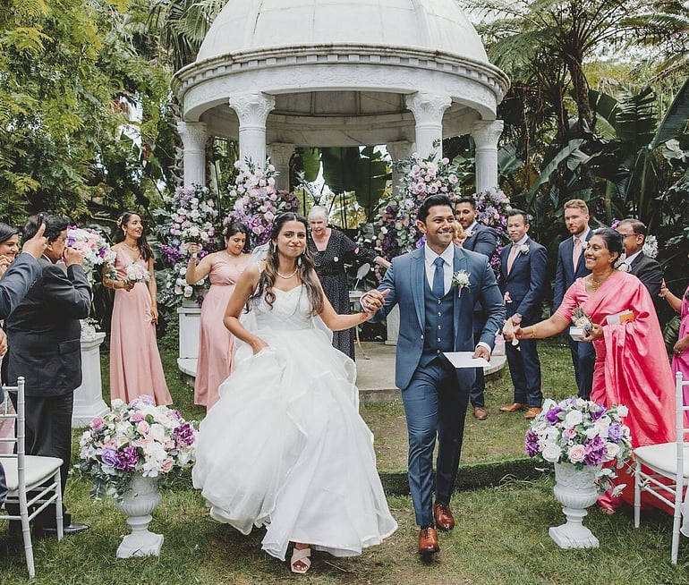 Indian wedding couple leaving their outdoor ceremony at Settlers Country Manor Auckland