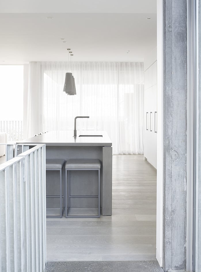 Kitchen island with polished bench top and luxury pendants