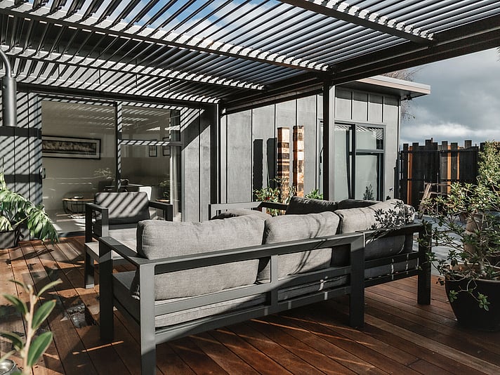 The project cover image shows a new home built in Topaz Drive in Papamoa. This new build shows a high level of workmanship completed by new home builders, Straight Up Builders Tauranga. The image is taken on the deck and shows the exterior board-and-batten cladding, the new deck, and the louvered pergola. 