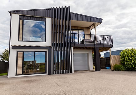Home renovated in a Papamoa by Straight Up Builders. This image shows the completed house with new roof, deck and cladding. 