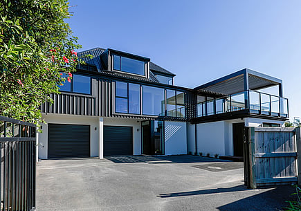 Home renovation completed by Straight Up Builders Tauranga. This image shows the completed property in Papamoa Beach, featuring new joinery, cladding, decking, and a pergola. 