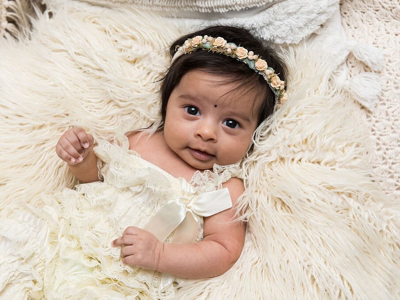 8 week baby looking at the camera with headband on